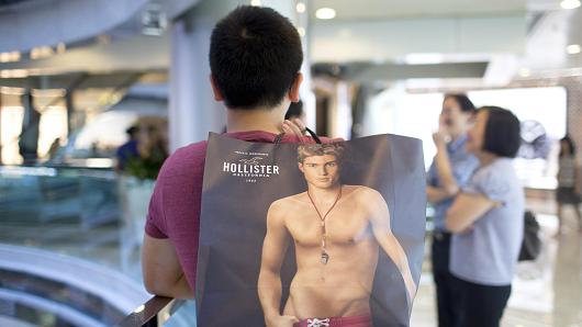 A shopper holds a shopping bag from Hollister operated by Abercrombie & Fitch Co