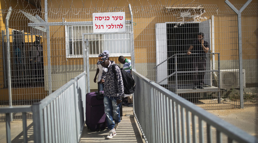 African migrants walk with their luggage as they leave Holot detention centre in Israel's southern Negev desert