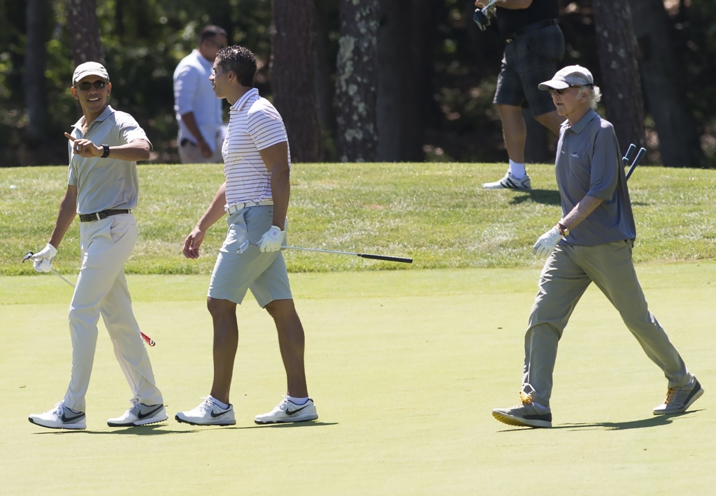 US President Barack Obama walks alongside Cyrus Walker and comedian Larry David as they play golf at Farm Neck Golf Club in Oak Bluffs on Martha's Vineyard in Massachusetts