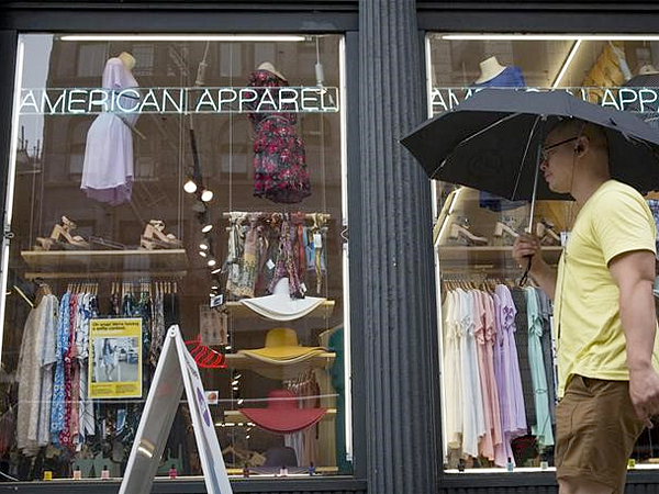 A man walks past an American Apparel store in New York