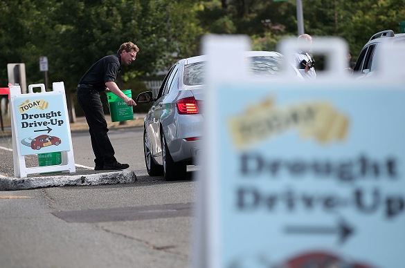 Ed Casey with Friedman's Home Improvement hands out a bucket filled with water conservation tools and literature during the Sonoma County Water Agency'Drought Drive Up event