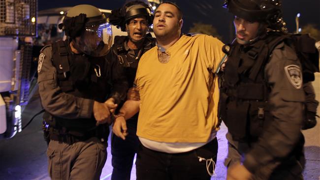 Israeli regime forces arrest a Palestinian man during a demonstration