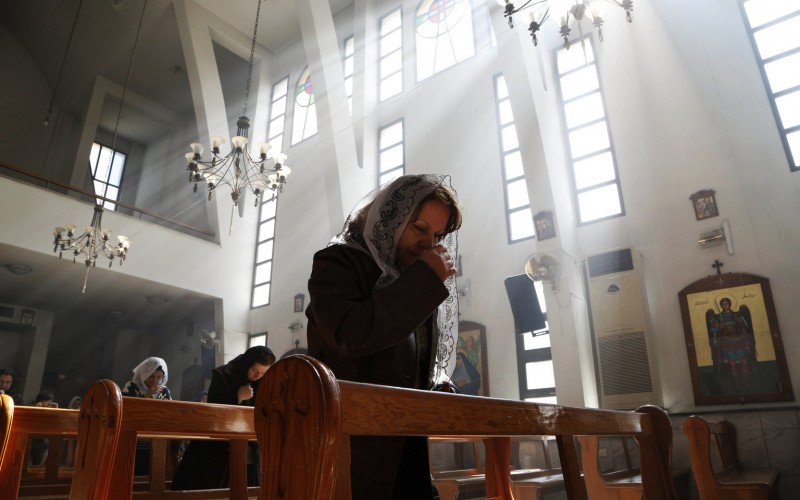 An Assyrian Christian prays at a church in Damascus