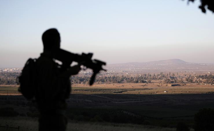 An Israeli soldier stands guard on the line separating Israel and Syria in the Golan Heights