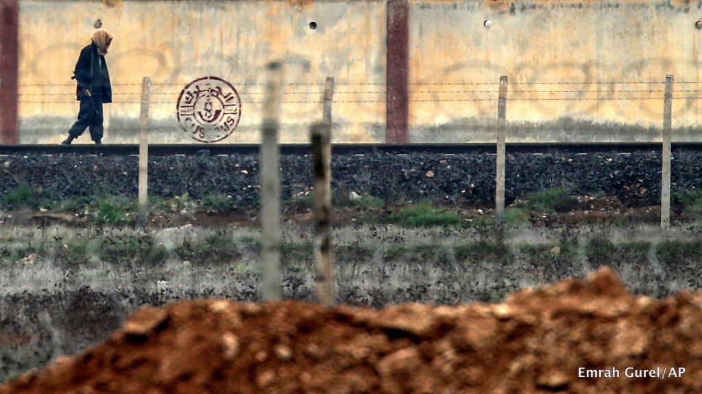 An armed man walks in ISIS controlled Tal Abyad across the Turkish Akcakale border gate Turkey