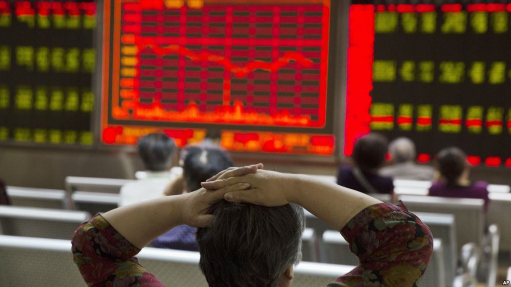 An investor watches a display of stock prices at a brokerage in Beijing