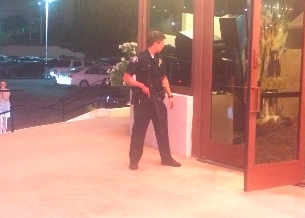 An officer is seen outside the Edwards Big Newport 6 movie theater on Aug. 8 2015