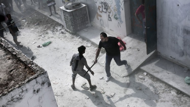 Angelos Tzortzinis  AFP  Getty Images      A Greek policeman hits a man with his baton during a registration procedure in Kos