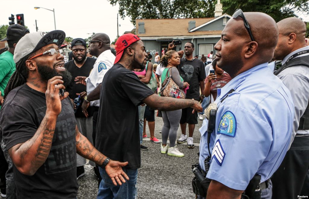 Area residents talk to police after a shooting incident in St. Louis Mo