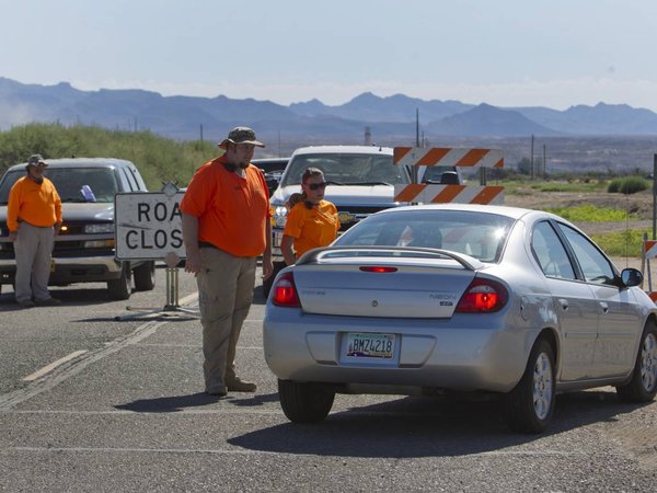 Mohave Valley Search and Rescue volunteer Chris Lyons center talks to a motorist at a road closure in Mohave Valley Ariz. Monday Aug. 10 2015. Most areas around the Willow Fire are still restricted. Eleven homes are reported to have been destroyed