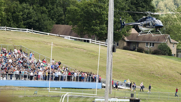 A West Virginia State Police helicopter lands on the football field at Philip Barbour High School in Philippi W.V. where students wait on bleachers after being evacuated after a hostage situation Tuesday. AP