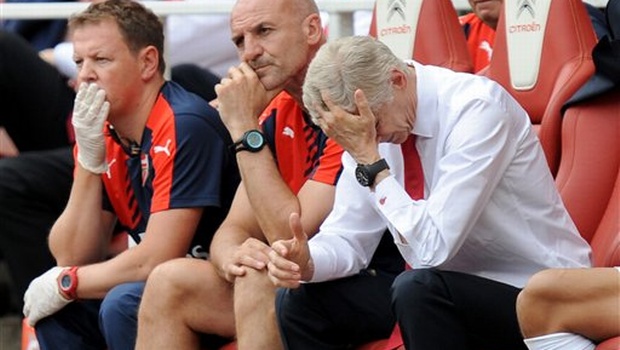 Arsenal manager Arsene Wenger right puts his hand to his head during the English Premier League soccer match against West Ham United at the Emirates Stadium