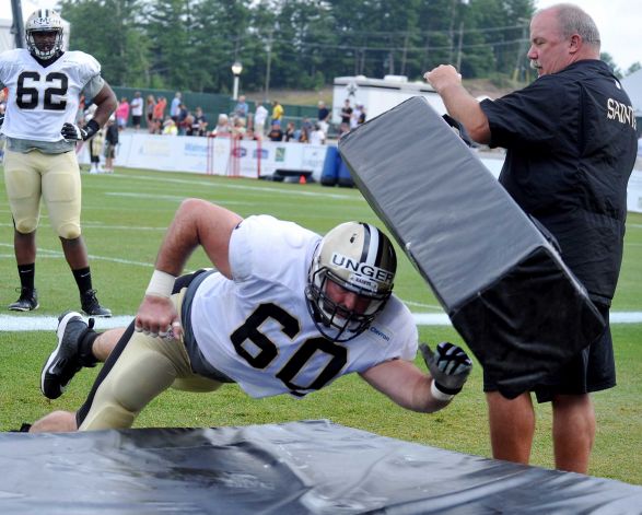 New Orleans Saints center Max Unger hits a mat during a drill at the team's NFL football training camp in White Sulphur Springs W. Va. Wednesday Aug. 5 2015