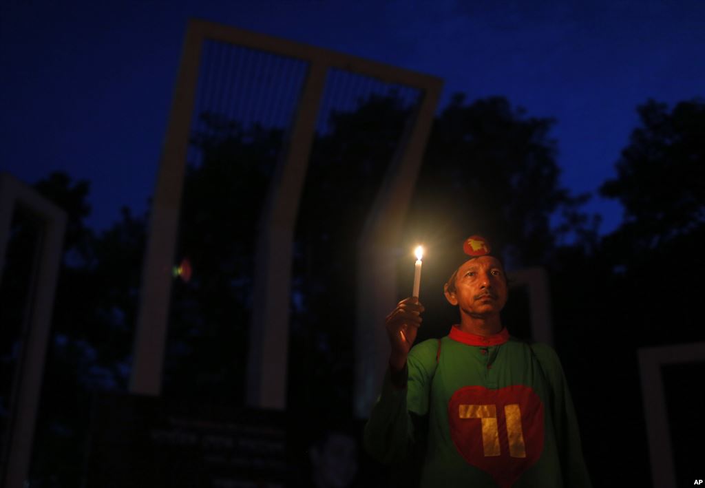 A Bangladeshi activist holds a candle as they protest against the killing of secular blogger Niladri Chottopadhay Niloy in Dhaka Bangladesh Friday Aug. 14 2015