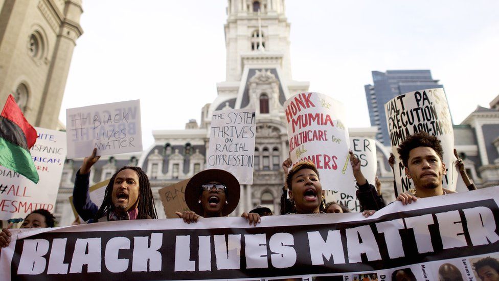 Protesters march past City Hall during a demonstration over the death of Freddy Gray outside City Hall on 30 April in Philadelphia Pennsylvania