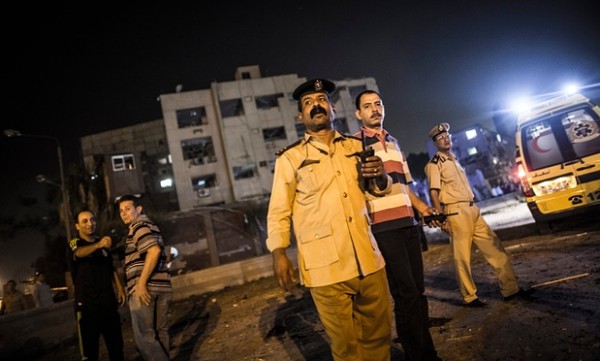 Police and security forces patrol the scene where a bomb detonated next to a national security building in the Shubra neighbourhood of Cairo