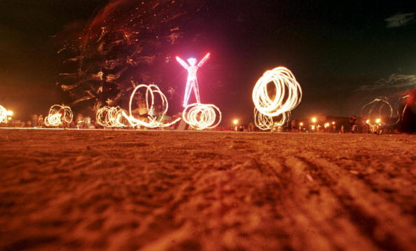 BLACK ROCK DESERT UNITED STATES Dancers at the'Burning Man festival create patterns with fireworks in the Black Rock Desert of Nevada just prior to burning a fivestory neonlit effigy of a man on the last night of the weeklong festival 06 Septembe