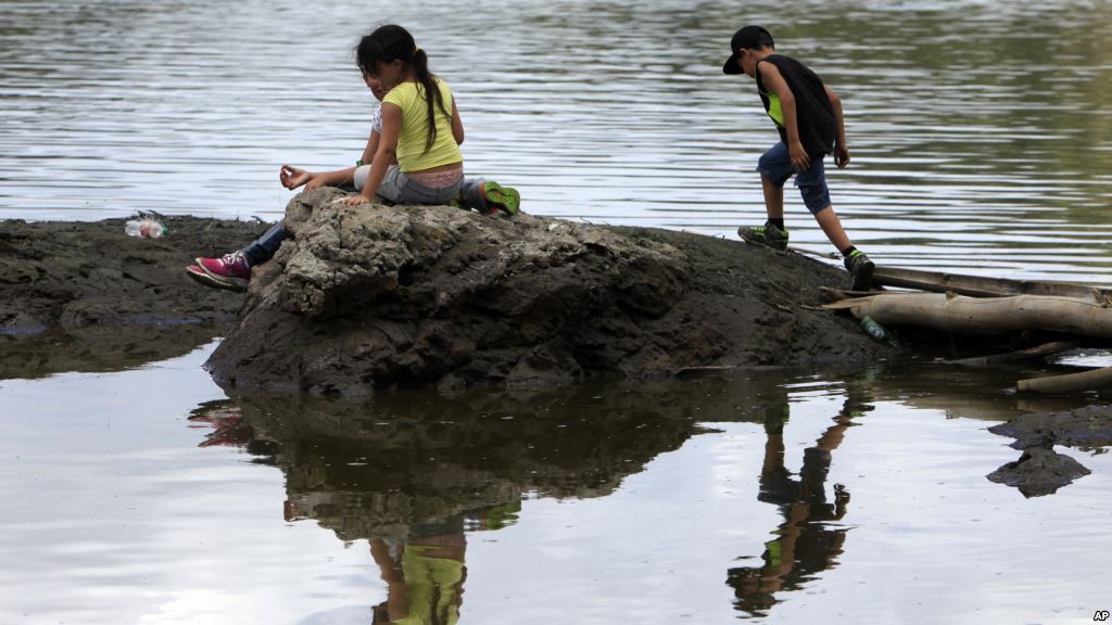 Children play on land partially exposed caused by a drought at the Carraizo reservoir in Trujillo Alto Puerto Rico Aug. 5 2015