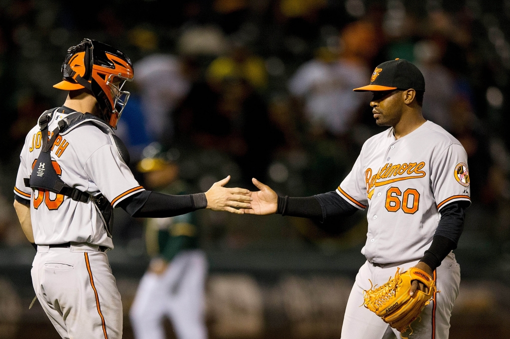 OAKLAND CA- AUGUST 03 Mychal Givens #60 of the Baltimore Orioles celebrates with Caleb Joseph #36 after the game against the Oakland Athletics