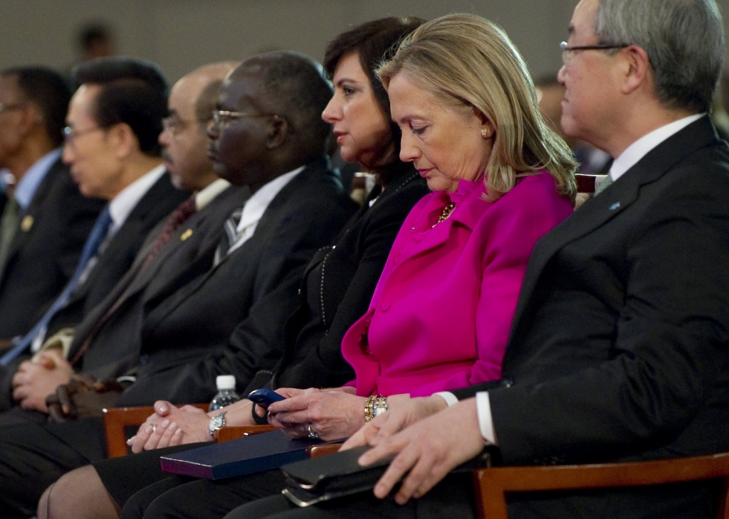 US Secretary of State Hillary Clinton checks her Blackberry phone alongside Korean Foreign Minister Kim Sung-hwan as she attends the Fourth High Level Forum on Aid Effectiveness in Busan Korea