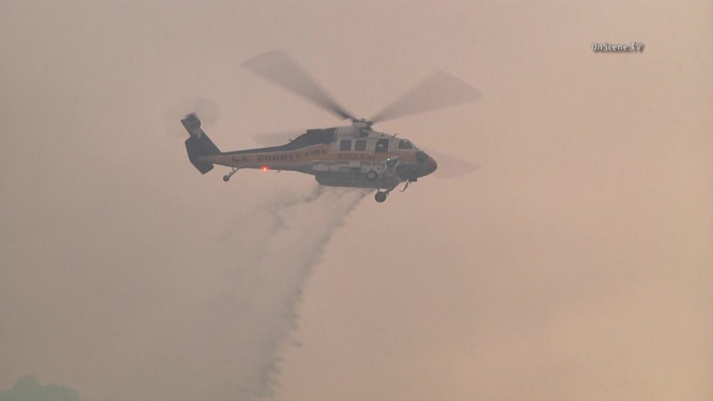 Los Angeles County Fire Department firefighters were assisting their colleagues in Ventura County today in the battle to extinguish a brush fire that scorched several acres north of the Ronald Reagan Freeway in Simi Valley