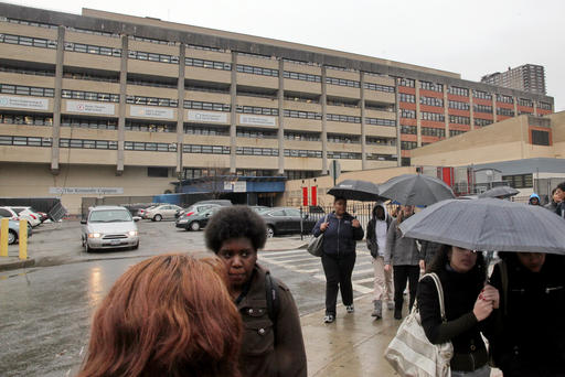 Students leave the John F. Kennedy multi-high school campus during afternoon showers in the Bronx