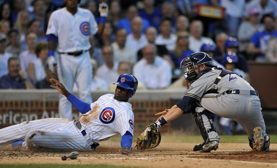 Soler left slides safely into home plate on a Dan Haren single as Milwaukee Brewers catcher Jonathan Lucroy tries to apply the tag during the second inning of a baseball game Tuesday Aug. 11 2015 in Chicago. (AP