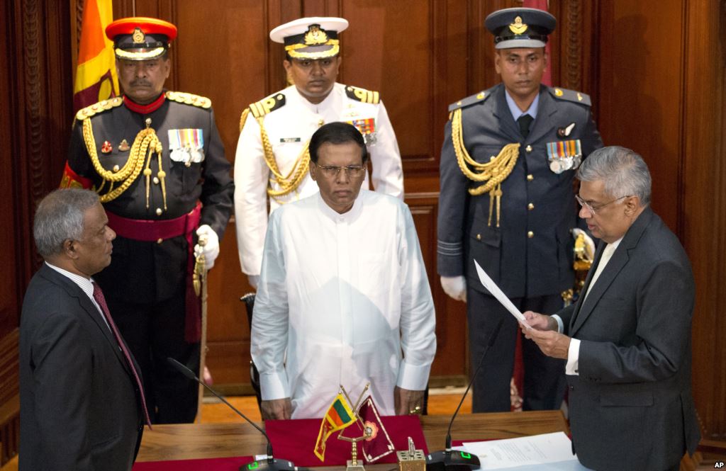 Ranil Wickremesinghe right takes oath as Sri Lanka’s prime minister in front Sri Lanka’s president Maithripala Sirisena center in Colombo Sri Lanka Friday Aug. 21 2015