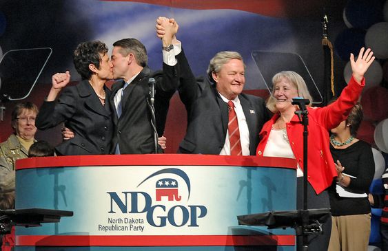 North Dakota Gov. Jack Dalrymple and first lady Betsy Dalrymple right wave to the convention delegates while Lt. Gov. Drew Wrigley and his wife Kathleen celebrate with a kiss after receiving a unanimous ballot at the