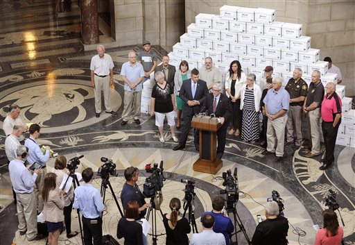 Death penalty supporters stand in front of boxes they say contain 166,692 petition signatures enough to block the repeal of the death penalty in Nebraska until voters decide the issue during a news conference Wednesday Aug. 26 2015 at the state capito