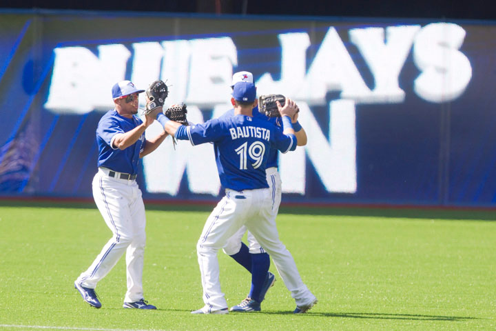 Toronto Blue Jays outfielders Jose Bautista Ben Revere left and Kevin Pillar come together in the outfield after defeating the New York Yankess 3-1 in their American League MLB baseball game in Toronto on Sunday