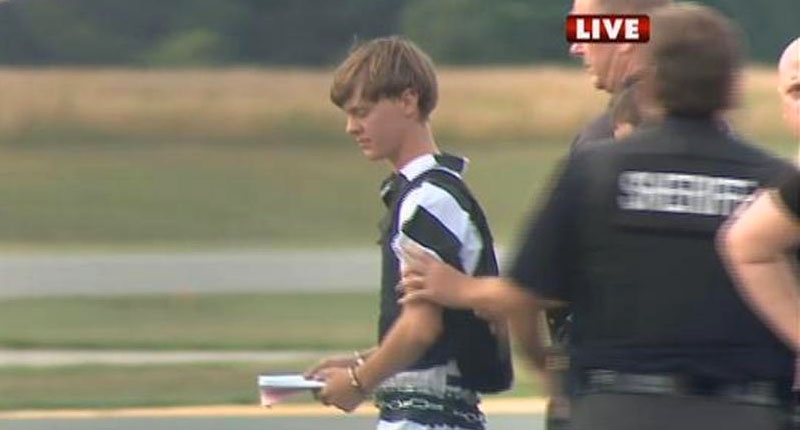 A WBTV News image shows shooting suspect Dylann Roof being escorted by police at the Shelby Cleveland County Regional Airport for extradition back to Charleston South Carolina