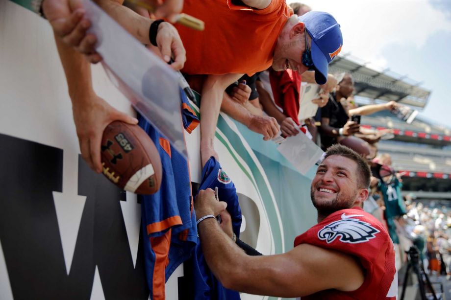 Philadelphia Eagles quarterback Tim Tebow signs autographs for fans after practice at NFL football training camp in Philadelphia. Tebow's throwing motion and mechanics are clearl