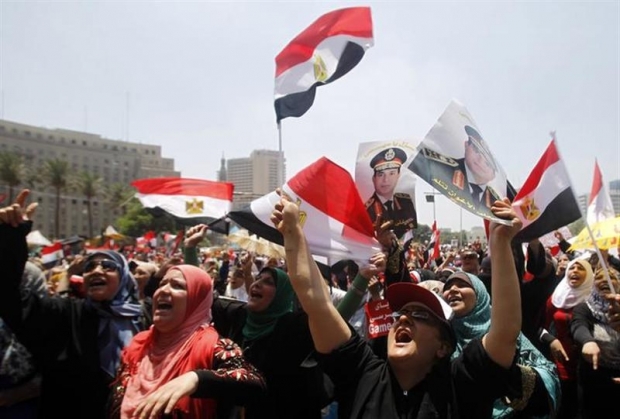 Protesters who are against former President Mohamed Mursi wave the Egyptian flags as they shout slogans during a rally at Tahrir square in Cairo