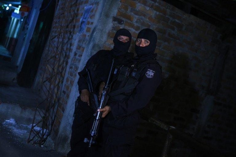 Members of the National Civil Police stand guard in the vicinity of Quezaltepeque prison where at least 14 inmates were killed when violence erupted between two factions of a notorious gang north of San Salvador