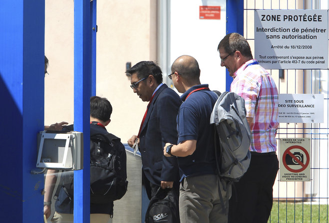 Malaysia's Department of Civil Aviation Director General Azharuddin Abdul Rahman second left arrives at the Direction Generale de l'Armement facilities in Balma near Toulouse south-western France Wednesday Aug. 5 2015 to start to examine an