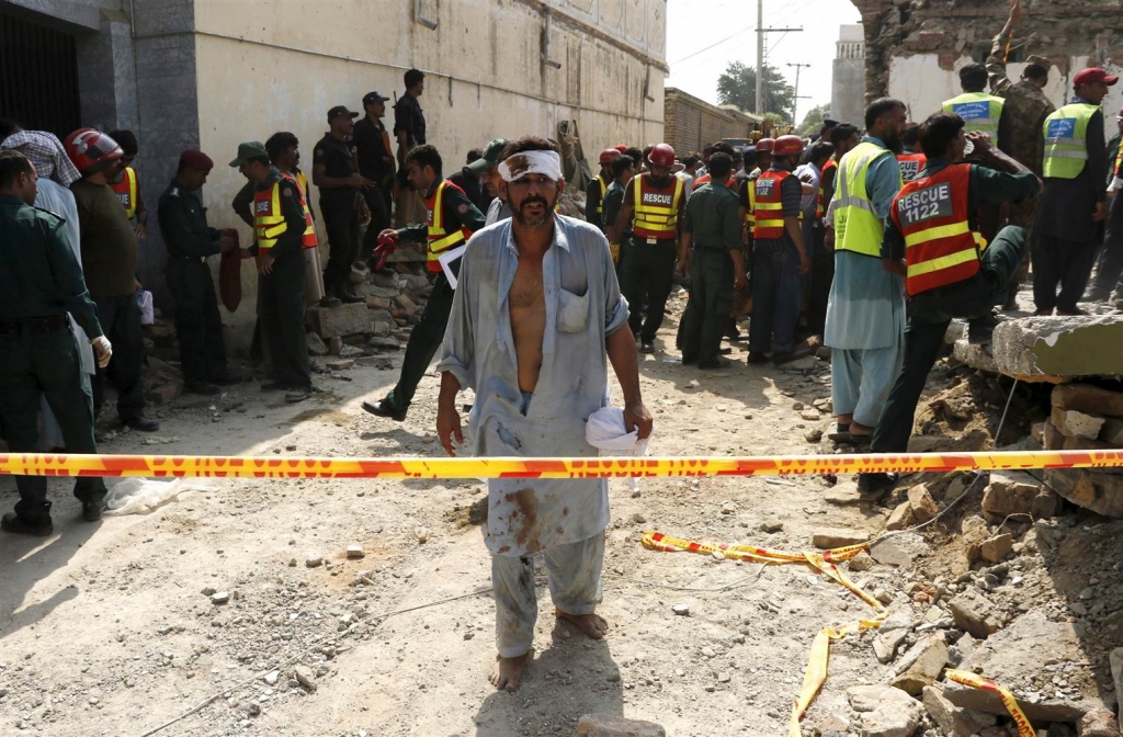 Image An injured man walks away as rescue workers search after a blast near the home of the home minister of Punjab province Shuja Khanzada in Attock