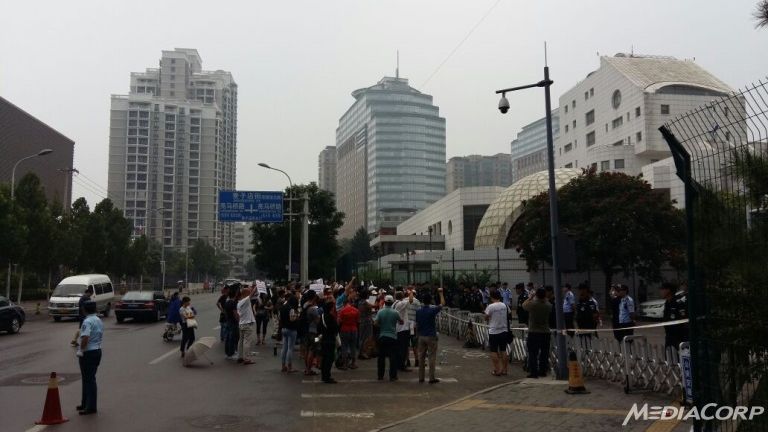 Family members of those on board Malaysia Airlines flight MH370 stage a protest outside the Malaysian embassy in Beijing