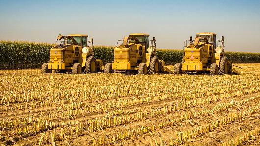 Three farm tractors in a freshly cut cornfield near Visalia California