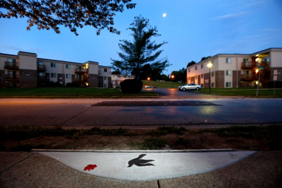 A dove is embedded in the sidewalk near the spot where Michael Brown was shot and killed by police officer Darren Wilson in Ferguson Mo. A year ago Ferguson was thrust into the national spotlight after the death of Brown gave way to the'Black Lives Mat