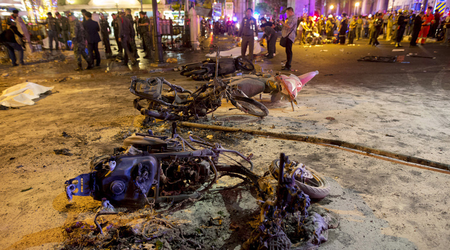 Wreckage of motorcycles are seen as security forces and emergency workers gather at the scene of a blast in central Bangkok