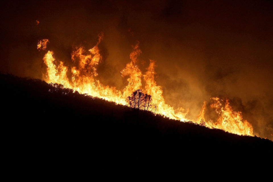 Flames roar along a ridge east of Clear Lake as the Rocky Fire advanced last weekend