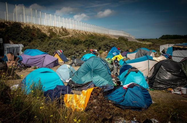 Migrants wait in a migrant camp called