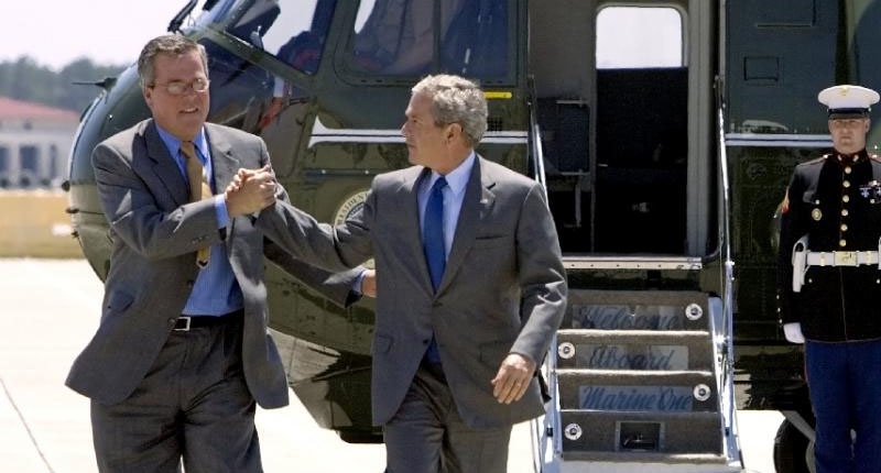 Jeb Bush shakes hands with his brother George W Bush as they step off Marine One at Mac Dill Air Force Base Florida