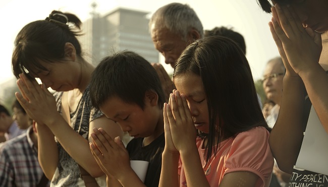 Visitors pray for the atomic bomb victims in front of the cenotaph at the Hiroshima Peace Memorial Park in Hiroshima western Japan Thursday Aug. 6 2015. Japan marked the 70th anniversary of the atomic bombing on Hiroshima