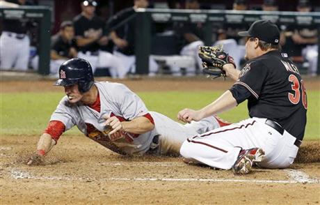 St. Louis Cardinals Randal Grichuk left scores on a wild pitch as Arizona Diamondbacks Wade Miley right applies a late tag during the third inning of a baseball game Saturday Sept. 27 2014 in Phoenix