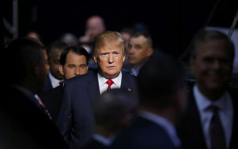 Republican 2016 U.S. presidential candidate businessman Donald Trump heads to the stage between Wisconsin Governor Scott Walker and former Florida Governor Jeb Bush for the start of the first official Republican presidential candidates debate