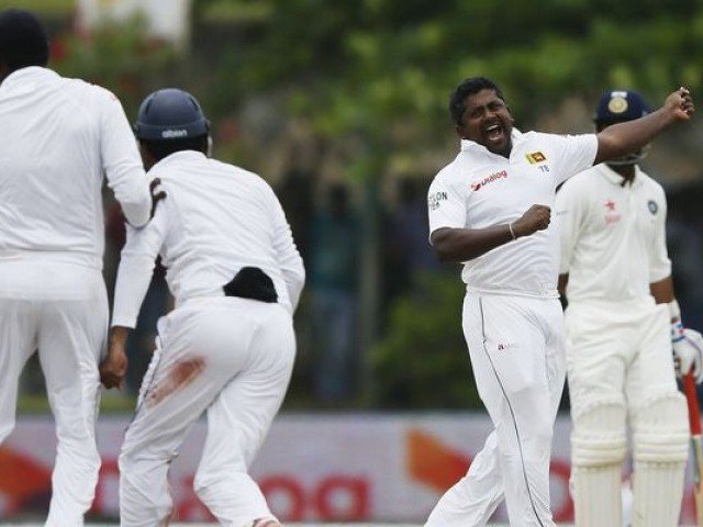 Sri Lanka's Rangana Herath celebrates with his teammates after taking the wicket of India's Harbhajan Singh during the fourth day of their first test cricket match in Galle