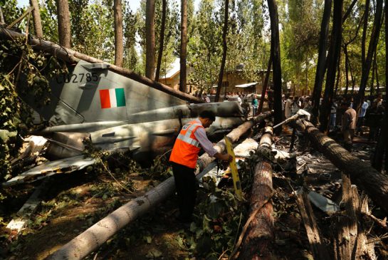 A Jammu and Kashmir State Disaster Response Force personnel examines the wreckage of Indian Air Force Mi G-21 aircraft after it crashed and landed in the fields near village Soibugh of Budgam district about 15 kilometres southwest of Srinagar