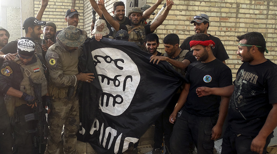 Iraqi security forces stand with an Islamist State flag which they pulled down at the University of Anbar in Anbar province